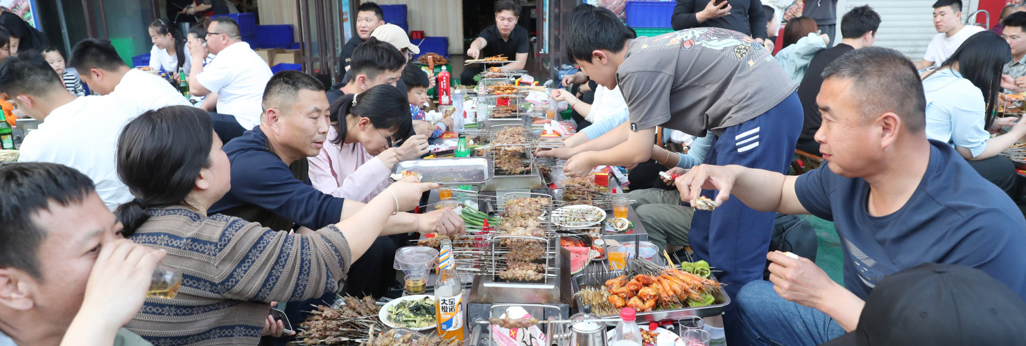 Customers eat skewers at Muyang Village Grill in Zibo, East China's Shandong province