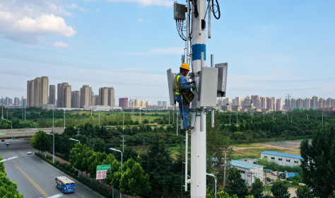 An employee of China Mobile Communications Group checks a 5G base station tower